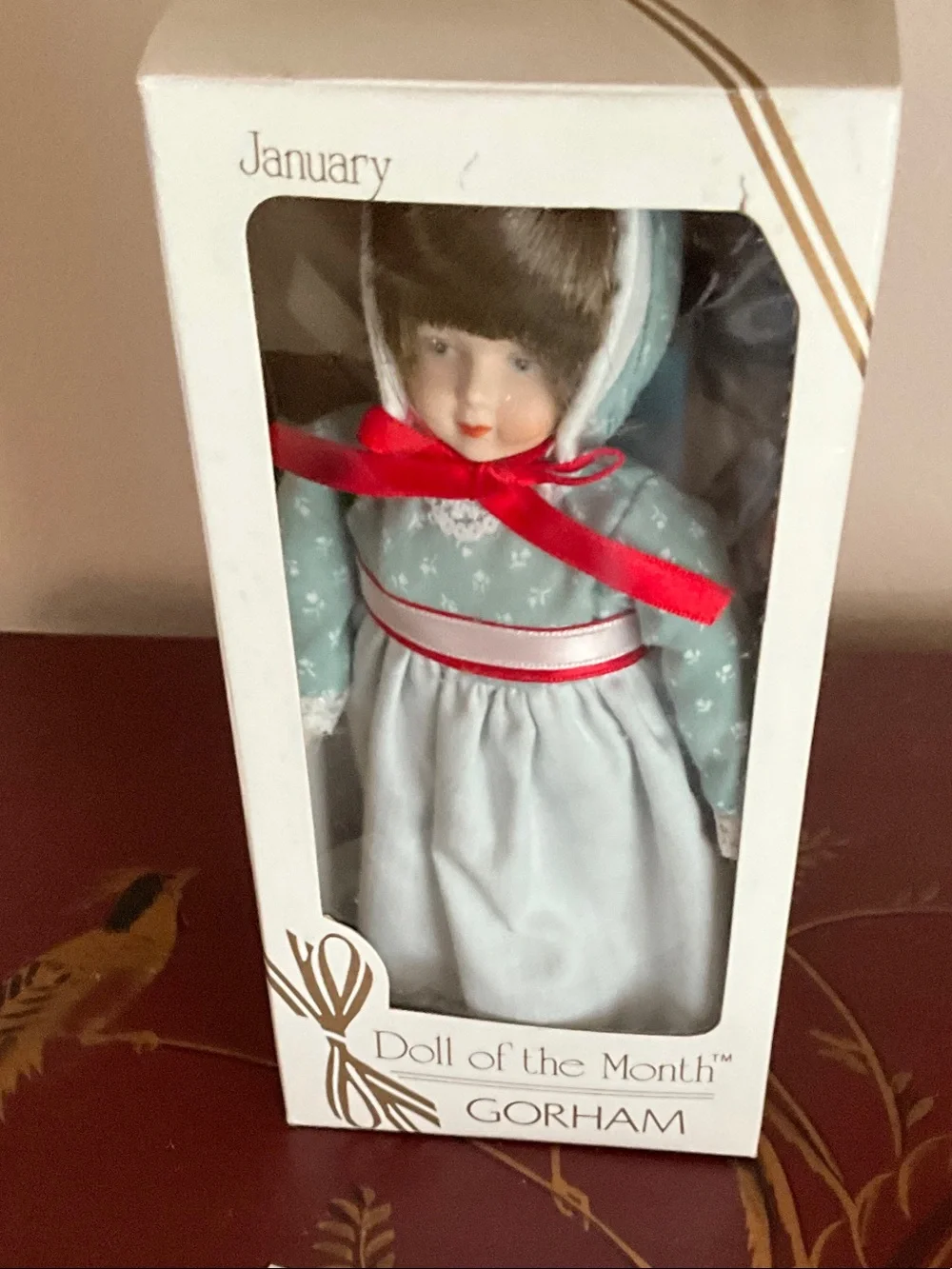 Porcelain Doll in Light Blue Dress with Red Ribbon Accents